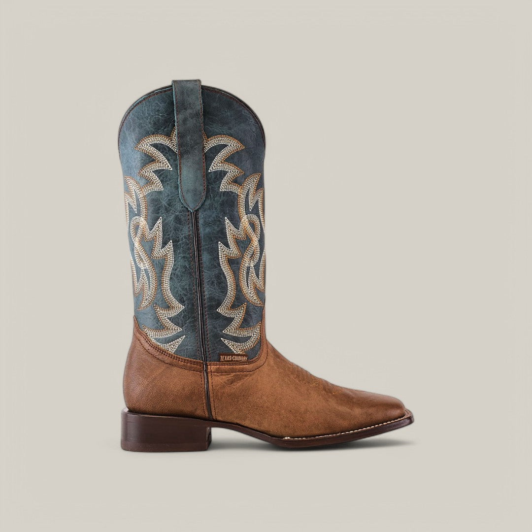 The Sierra Cinnamon - Square Toe boot features a Western design with a brown leather foot, blue shaft, and intricate white and tan stitching. Crafted from premium leather, it includes a square toe and low heel on a plain beige background.