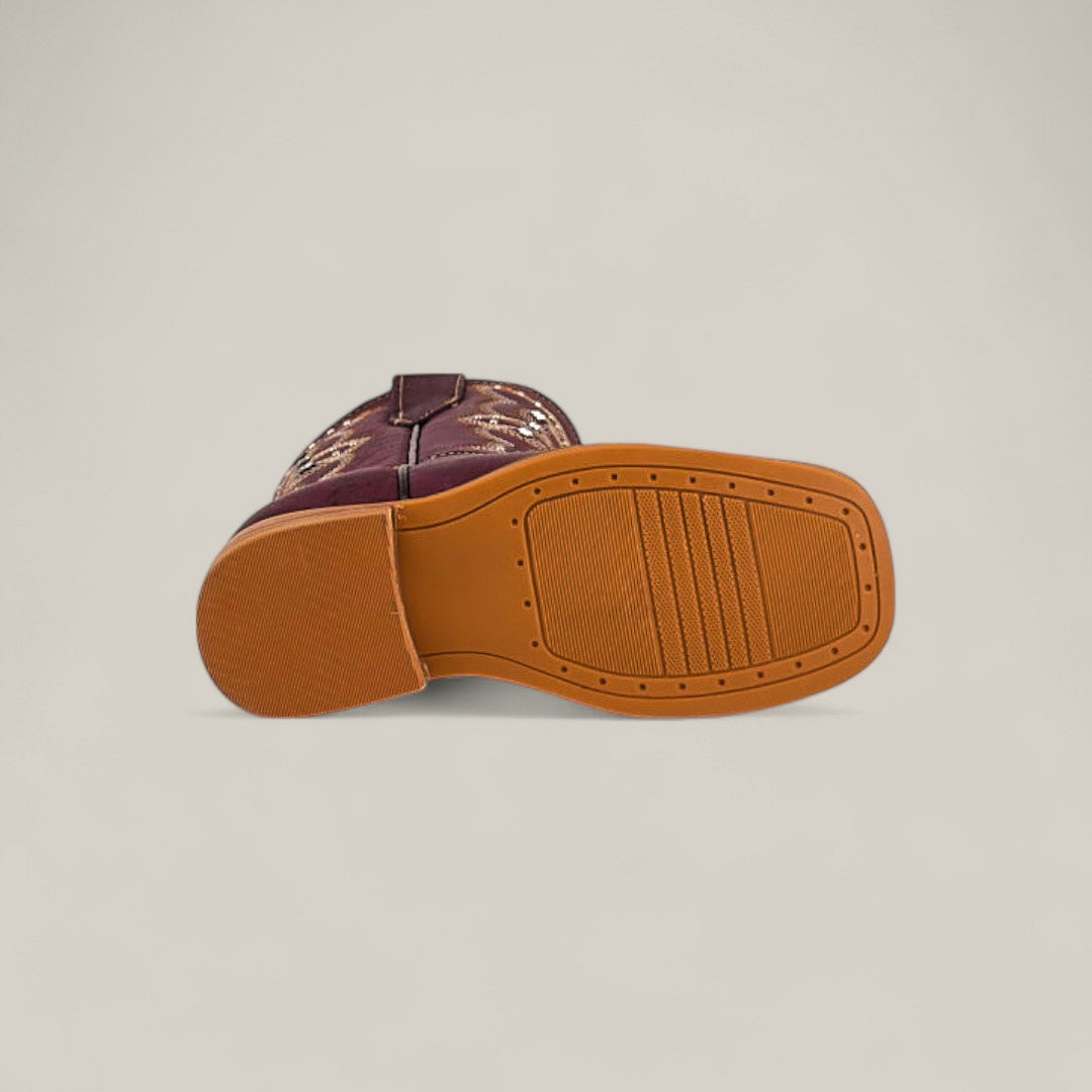 The image shows the Blake Purple - Square Toe - Kids Boots with a maroon upper featuring decorative stitching and a brown rubber sole with textured grip, combining trendy design, style, and comfort.