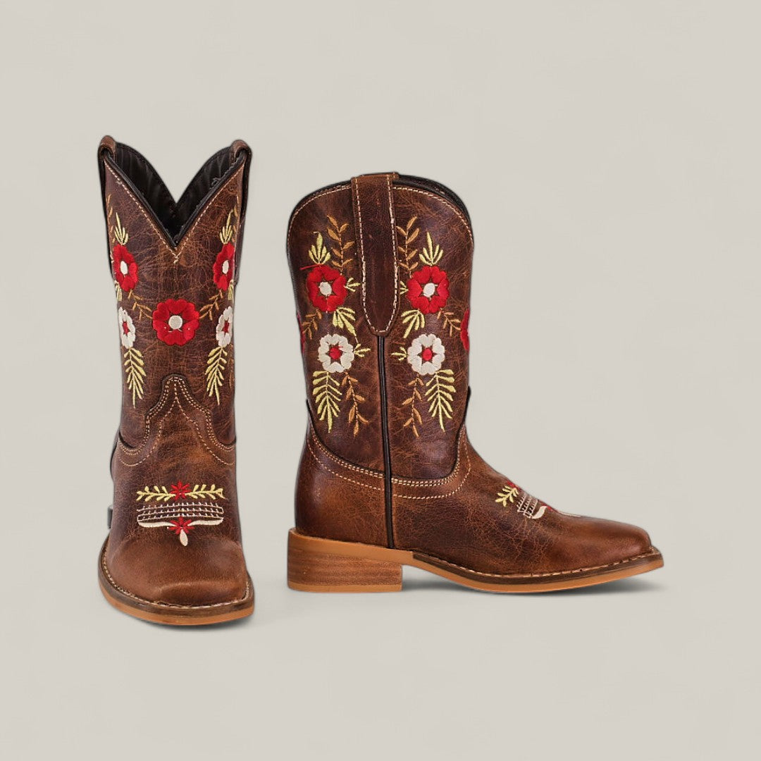 The Karo Brown Square Toe Kids Boots feature red and white floral embroidery with green leaf details on the shafts and toes, offering a classic design that blends comfort and elegance, shown against a plain light background.