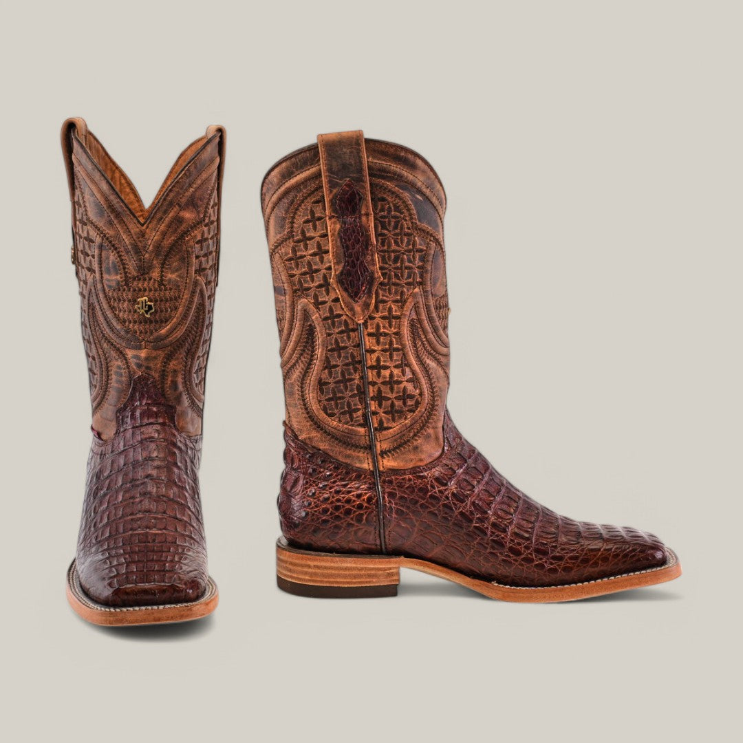 A pair of Exotic Caiman Horn Back boots in brown, showcasing intricate stitched patterns and a crocodile print texture. Crafted from genuine leather, they have a slightly worn look with square toes and stacked heels. One boot is upright, the other to the side.