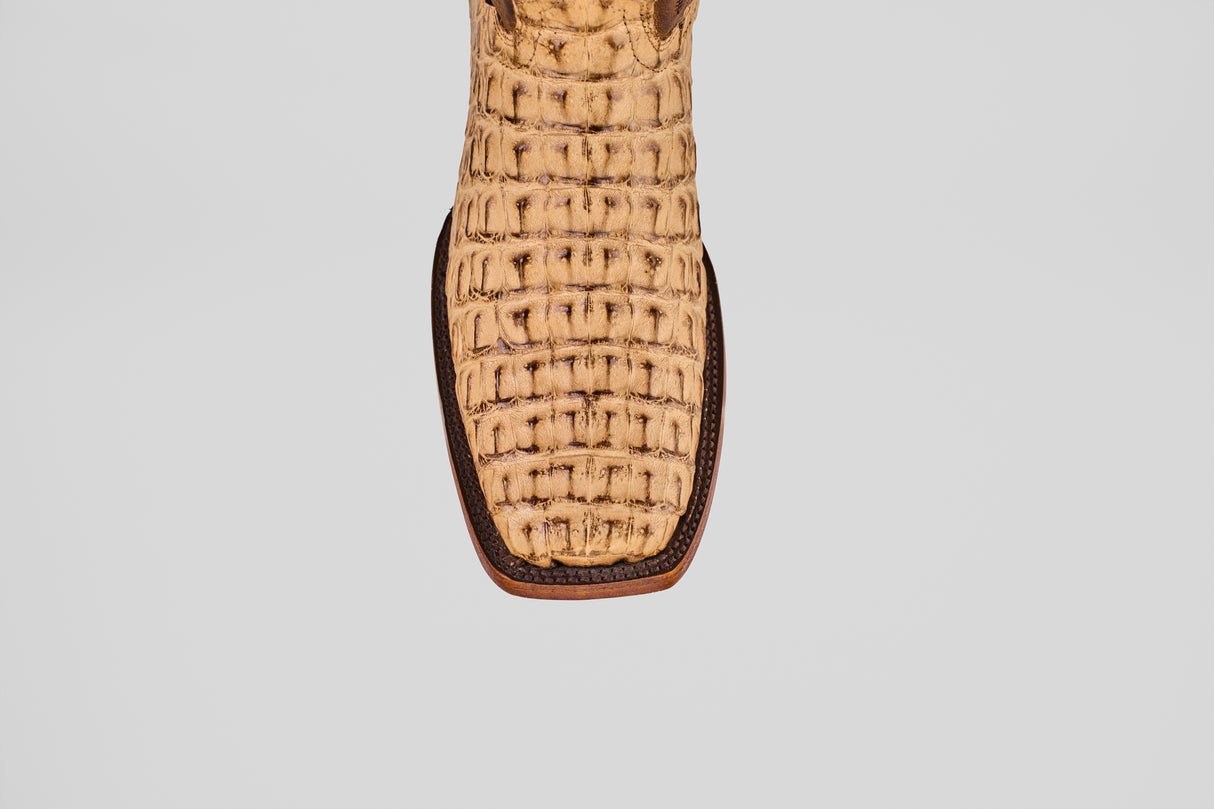 Close-up of the front of the Exotic Caiman Hornback - Antique - Rodeo Toe boot, featuring light brown caiman leather with a textured, woven pattern and darker trim, shown against a plain white background.