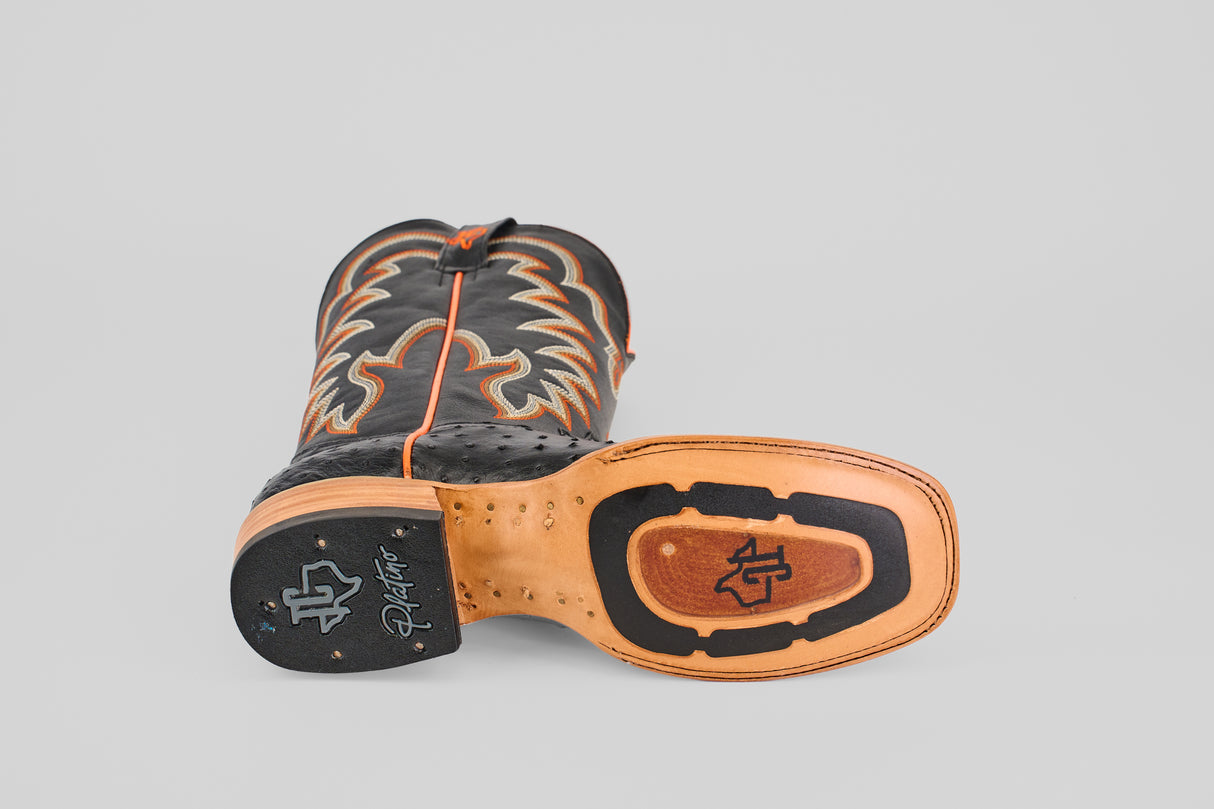 The Steele - Black - Square Toe boot features a distinctive stitched logo and tread on the sole, plus decorative light stitching on black and brown leather uppers, highlighting its luxury appeal.