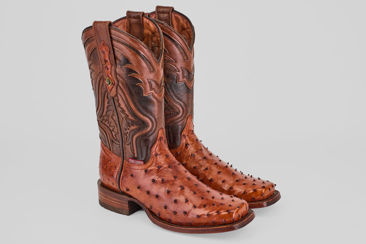 Exotic Ostrich - Brandy - Rodeo Toe boots with brown leather uppers, decorative stitching, and textured reddish-brown genuine ostrich leather on the foot are displayed on a plain light background.