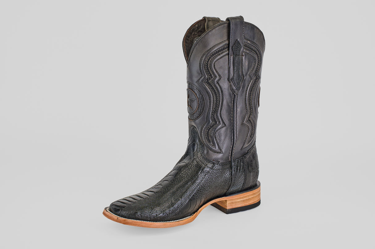 The Austin Leg - Black - Square Toe is a single black cowboy boot with decorative stitching, a square toe, and a light brown wooden heel, displayed on a plain light gray background. Ideal for fans of classic cowboy boot style.