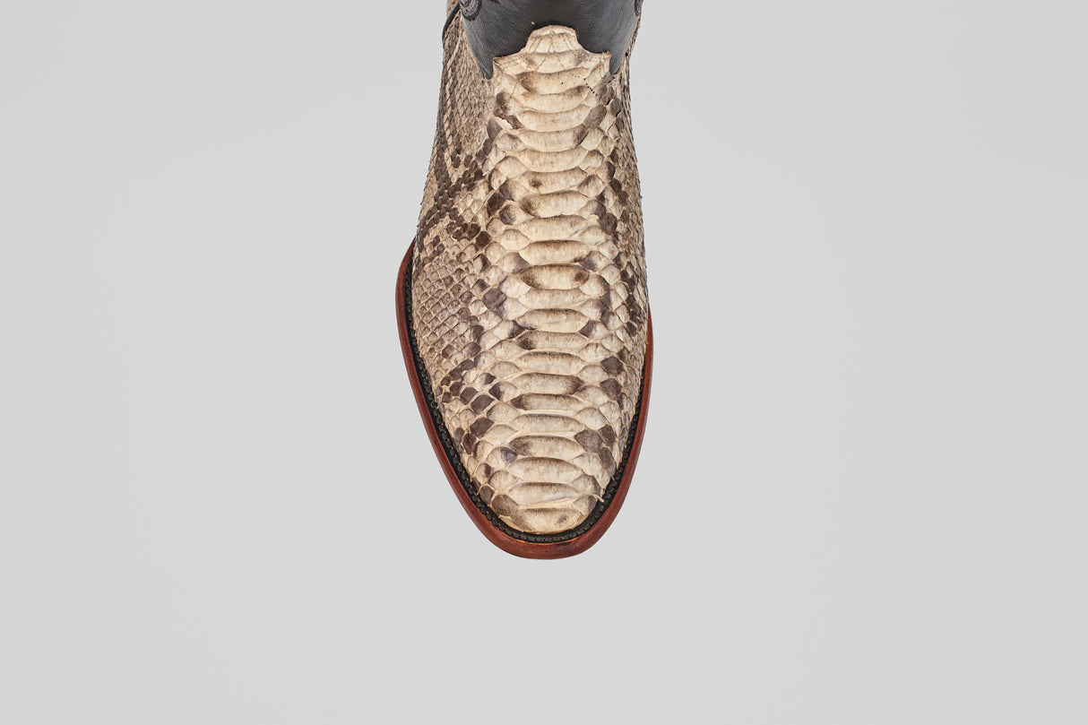 A top view of the Tanner - Natural - Roper Toe boot features beige and brown python snakeskin with a pointed toe, set against a plain light gray background.