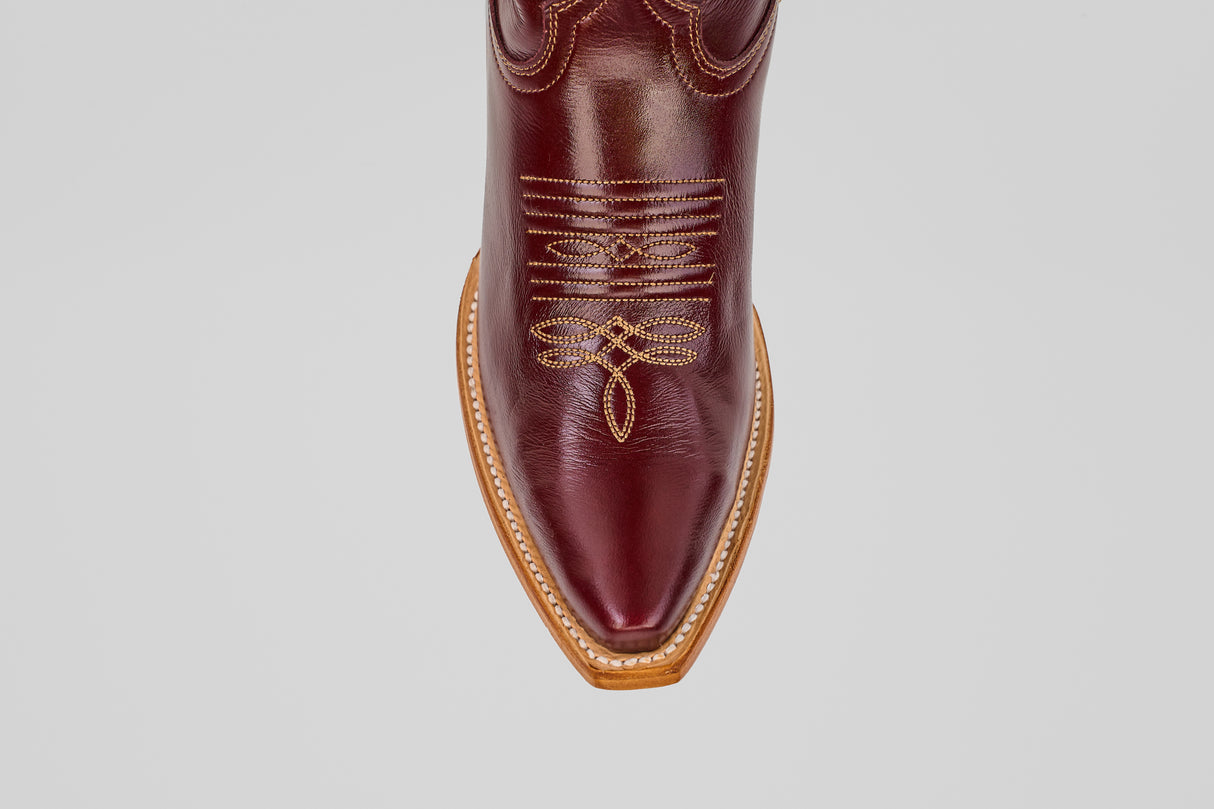 A top view of the Allison Blackberry - Tall Shaft - Snip Toe women’s Western boot, featuring a brown design with intricate yellow stitching and a tan sole, set against a plain light gray background.