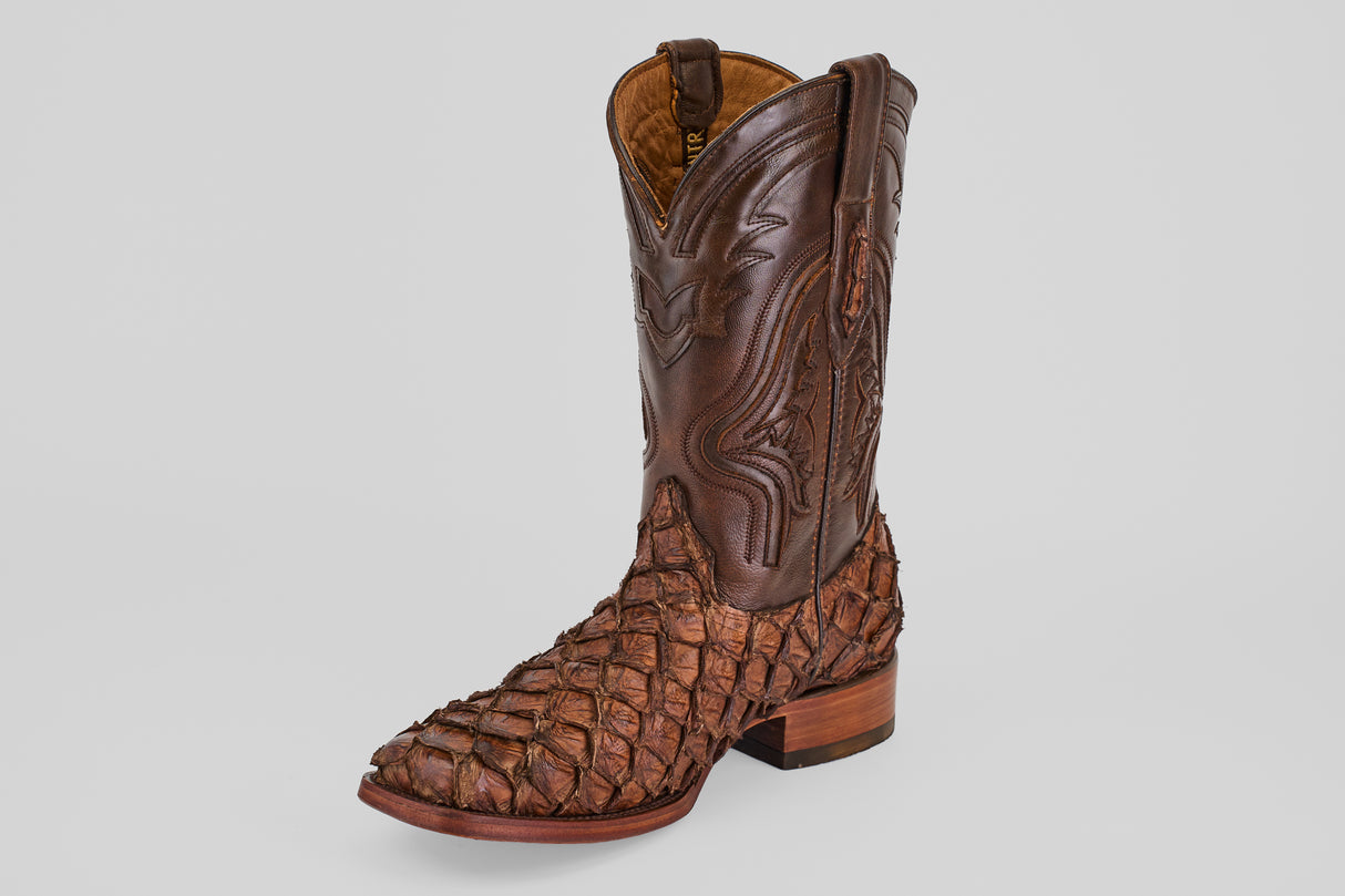The Conor - Brown - Rodeo Toe boot features decorative stitching on the shaft and a textured, scaly pattern on the foot, displayed against a plain light gray background.