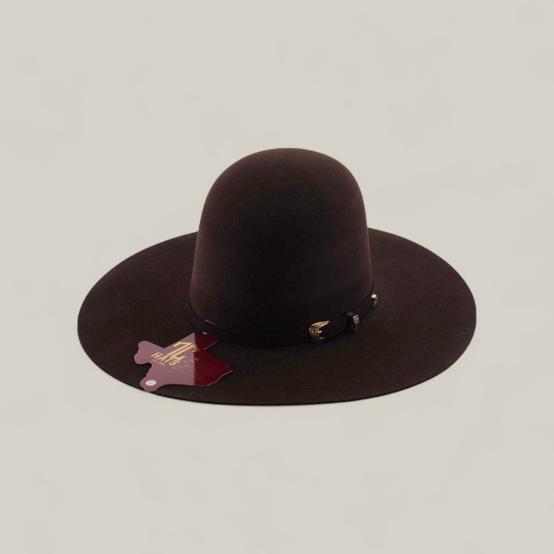 The 10X - Chocolate - TC Hats is a wide-brimmed, dark brown Western hat with an Open Crown Texana shape, decorative band, and maroon tag, displayed on a plain beige background.