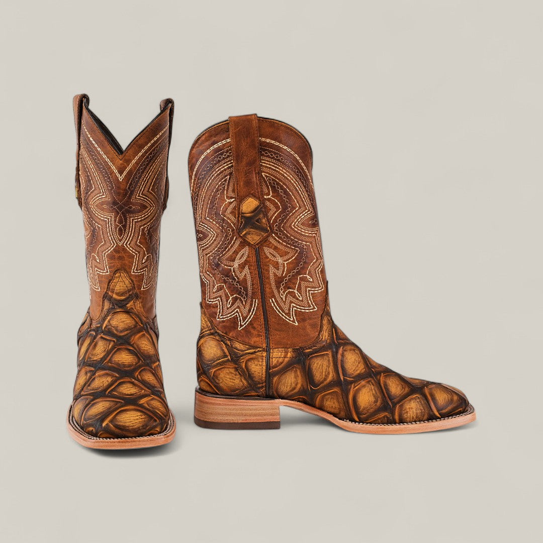 The Big Bass Pirarucu Print Rustic Honey - Square Toe boots feature intricate white shaft stitching and a distinctive Pirarucu-inspired textured lower, shown against a simple light background.