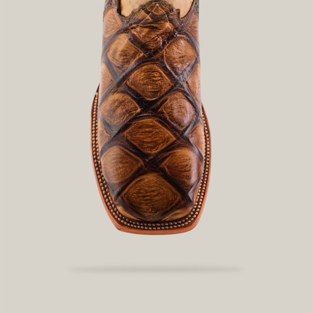 A single Big Bass Pirarucu Print Rough Orix Square Toe cowboy boot in tan and brown, featuring a Pirarucu print on the lower half and decorative stitching on the upper shaft. Crafted from premium cowhide, it is elegantly displayed on a white background.