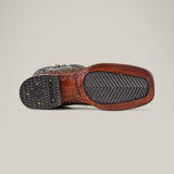 The image features the bottom view of the Exotic Python - Rustic Bone - Square Toe boot, with a textured rubber heel and sole, intricate stitching on python leather, and an engraved brand logo near the arch. Its herringbone-patterned front sole enhances its Western appeal.