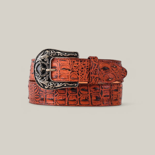 The Caiman Print Cogñac Belt, adorned with a detailed Texas buckle featuring star motifs, is elegantly coiled on a neutral background.