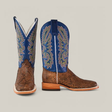 The Exotic Python Tamarindo boots feature brown textured leather with blue upper shafts adorned in colorful embroidery, a modern square toe design, and stacked wooden heels.