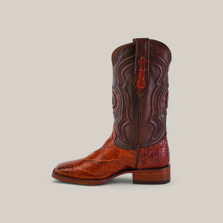 The Exotic American Alligator Hornback - Cogñac boot features a tan crocodile-patterned leather foot and a dark brown intricately stitched shaft, with a square toe design, medium heel, and side pull strap against a plain light background.