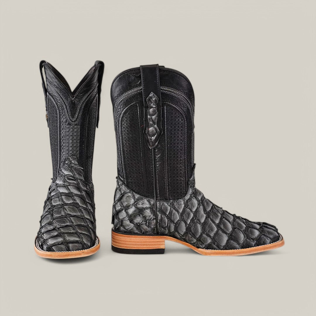 The Exotic Pirarucu Fish - Newspaper features black cowboy boots made from fish leather with a reptile texture, square toe design, classic leather details, elevated heel, and natural-colored soles.