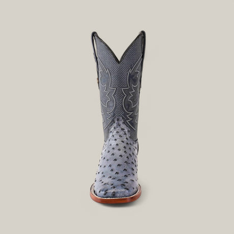 Front view of the Exotic Full Quilt Ostrich - Safari Gray - Square Toe boot, crafted from Exotic Full Quilt Ostrich leather, featuring a textured pattern with intricate grey and black stitching on a plain beige background.