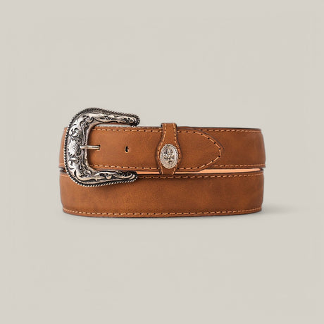 The Honey Plain Belt - Rustic Buckle, a handcrafted leather belt with an ornate engraved metal buckle, is rolled and displayed on a beige background, exuding timeless style.