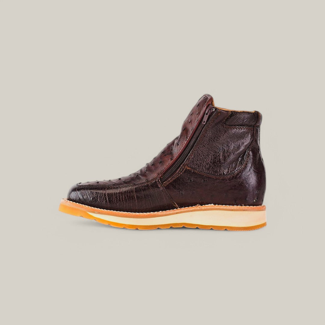 Side view of the Exotic Ostrich ankle boot in dark brown, showcasing its luxurious texture. It includes a side zipper and a tan wedge sole, all set against a plain light gray background.
