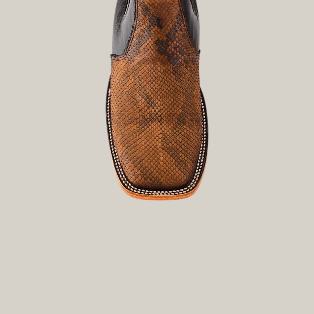 A close-up of the Exotic Python - Tamarindo ankle boot, featuring python-embossed leather with a snakeskin texture and unique sole stitching, against a plain background.