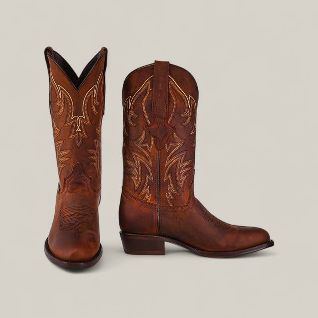A pair of Dutton - Brick - Roper Toe boots in brown cowhide, featuring intricate light stitching, is displayed on a plain light background—one boot facing forward, one from the side—from the Last Call collection.