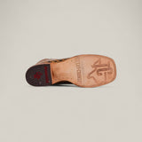 The Jonh - Orix - Square Toe boot features a flat tan leather sole stamped with “TEXAS COUNTRY” and a bold TC logo. Its dark heel displays a red Texas Country emblem set against a plain, light background.