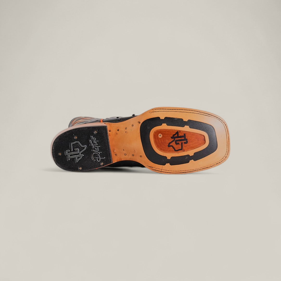 The image shows the sole of the Exotic Full Quilt Ostrich - Black - Square Toe, featuring a tan and black design with stylized logos and signature. Made from premium ostrich leather, it’s part of the luxurious Platinum Collection.