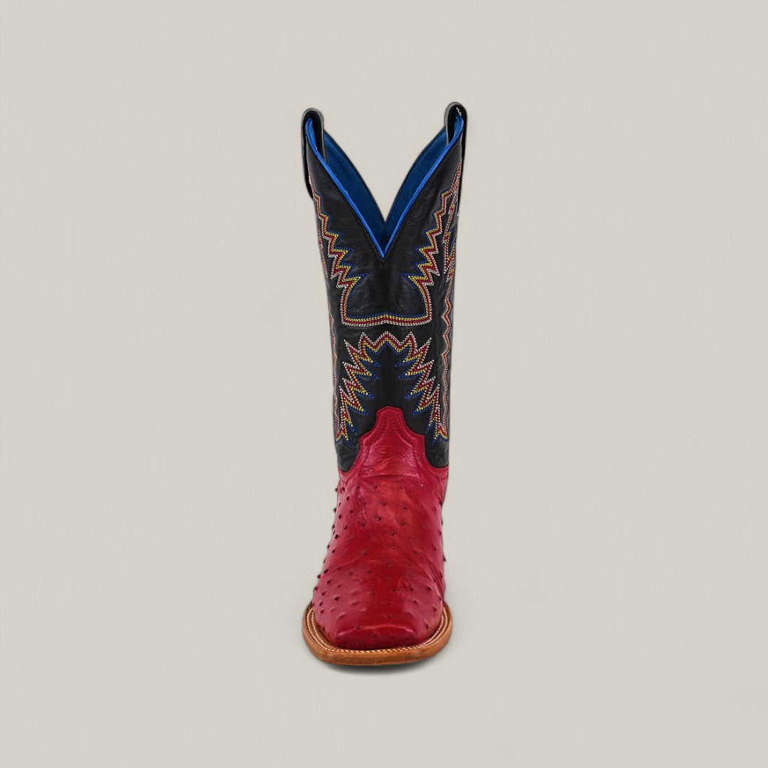 The Exotic Full Quilt Ostrich - Red - Square Toe boot from the Platinum collection features a red ostrich-textured lower, square toe, tan sole, and tall black shaft with colorful embroidery and blue lining, shown facing forward.