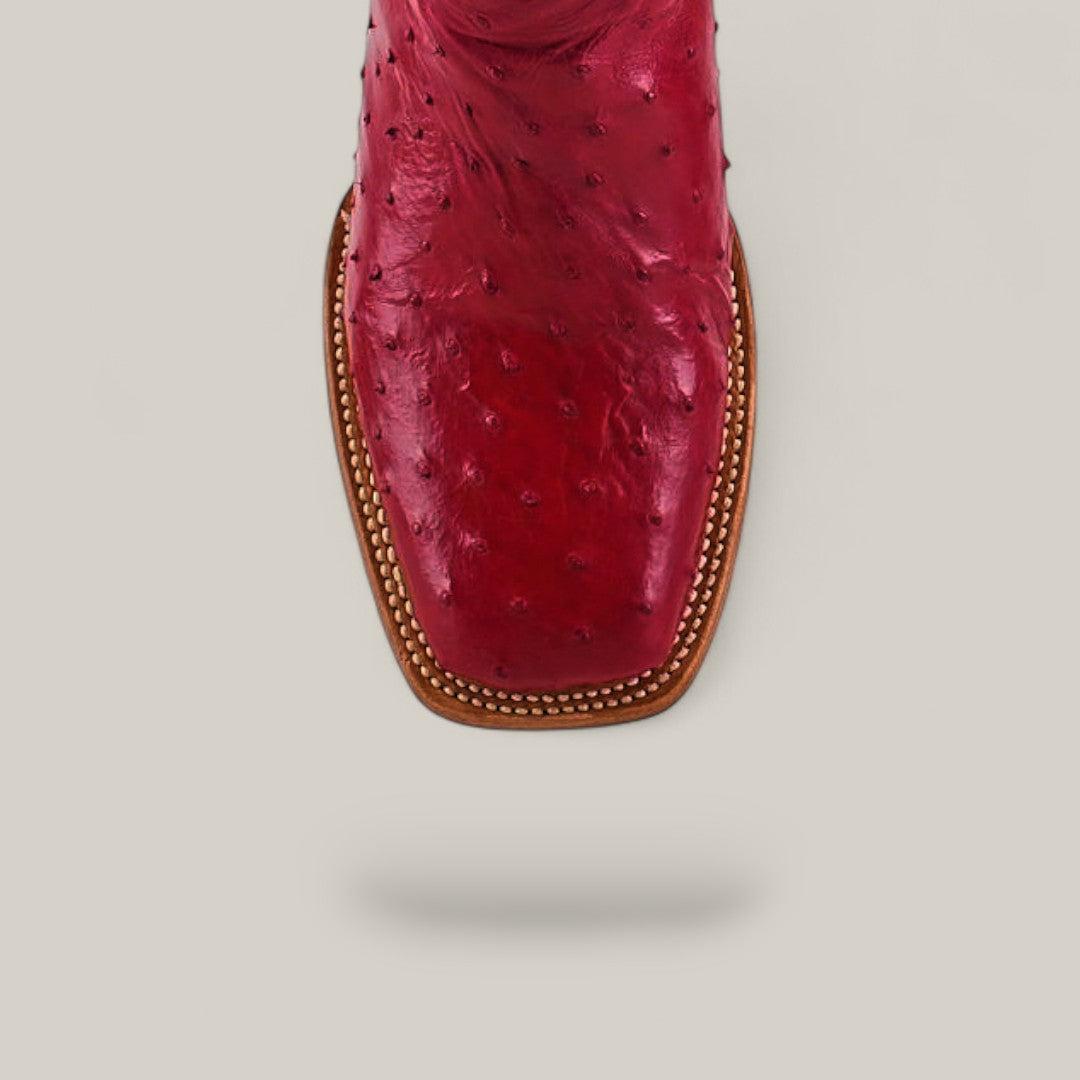 A close-up, top view of the Exotic Full Quilt Ostrich - Red - Square Toe boot, featuring detailed stitching and a square toe design, set against a light gray background.
