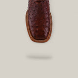 Close-up of the Exotic Full Quilt Ostrich - Red / Brown - Square Toe boot, highlighted from above to showcase decorative stitching, part of the Platinum Collection, displayed on a light beige background with a subtle shadow.