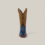 The Exotic Full Quilt Ostrich - Blue - Square Toe boot, featuring a blue textured lower and brown upper with yellow stitching, is displayed upright and forward against a plain light background.