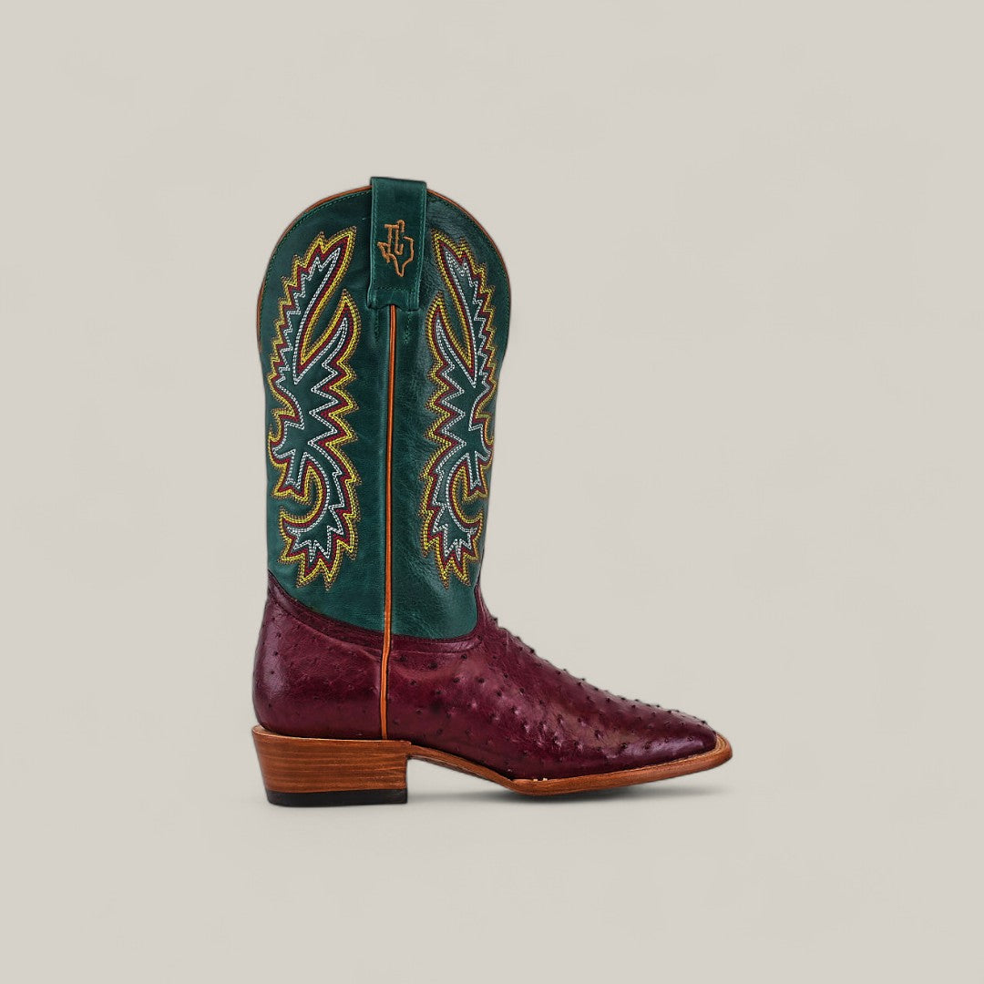 The Exotic Full Quilt Ostrich - Wine - Square Toe boot features a burgundy ostrich lower, square toe, green embroidered shaft, and wooden heel, displayed on a neutral background.