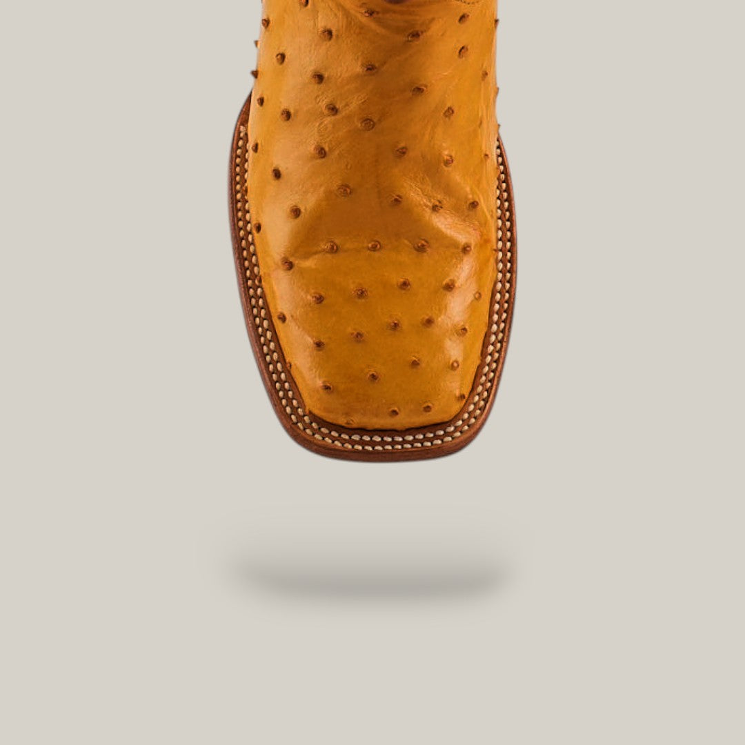 A close-up of the toe on the Exotic Full Quilt Ostrich - Buttercup - Square Toe boot, featuring visible quill bumps and intricate stitching, shown against a plain light gray background.