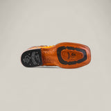 The underside of the Exotic Full Quilt Ostrich - Buttercup - Square Toe boot from the Platinum Collection features a textured sole with black and tan sections, logos, and branding. The polished leather finish adds an elevated touch.