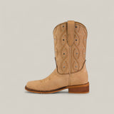 The Premiere Suede Bone - Square Toe Kids boot features premium tan suede, decorative stitching, small silver studs, a wooden heel, and a top loop, shown against a plain light background.