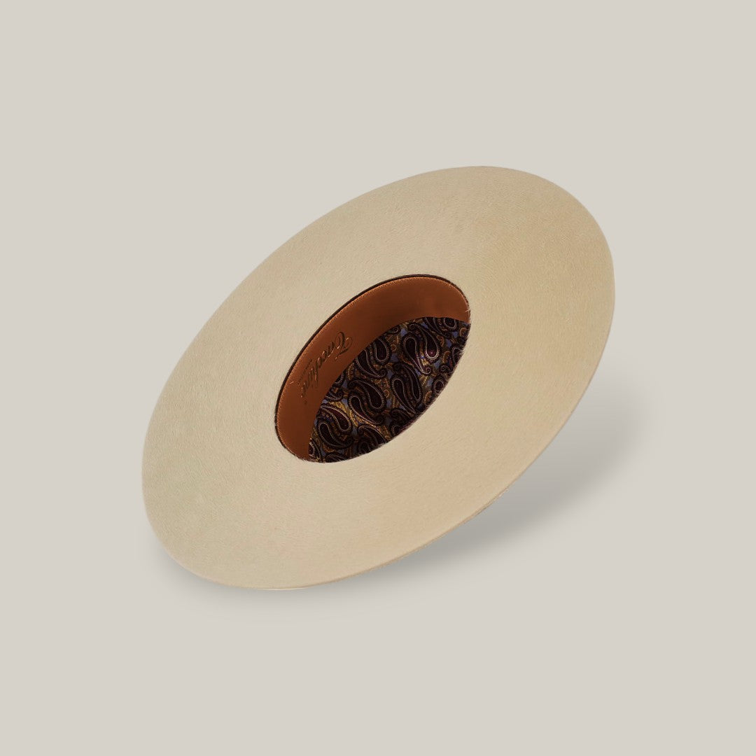 The 10X Grizzly - Tacchino is a beige felt hat featuring an open crown with a circular center opening, patterned inner lining, and brown leather sweatband, shown against a light background.