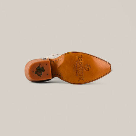 The image shows the sole of the Kellie Frost White Leather Sole boot with a tall shaft and snip toe, featuring embossed TEXAS COUNTRY branding and logo. The white boot is set against a plain, light beige background.