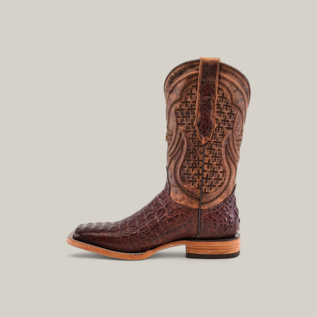 The Exotic Caiman Horn Back is a western-style cowboy boot with intricate patterns, a genuine leather finish, a square toe, and a low stacked heel, displayed against a plain light gray background.