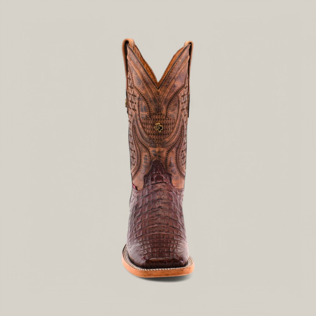 The Exotic Caiman Horn Back - Brown - Square Toe cowboy boot features intricate stitching and a crocodile-like finish, set against a plain gray backdrop, showcasing the rugged elegance of genuine leather.