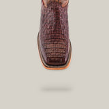 The Exotic Caiman Horn Back - Brown - Square Toe boot is made of genuine leather with a crocodile-textured finish, featuring a top-down view on a light gray background, showcasing its square toe and intricate decorative stitching.