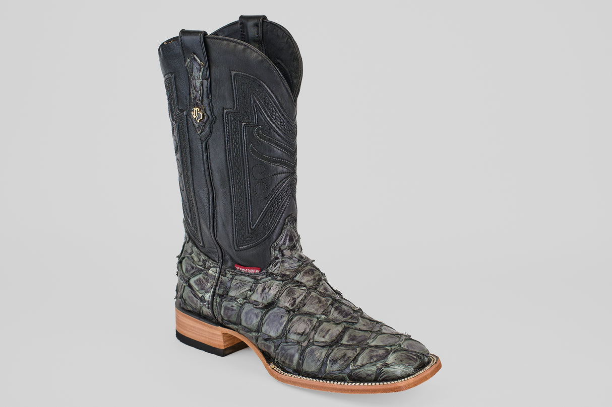 The Conor - Charcoal - Square Toe is a men’s cowboy boot with a textured dark gray and black fish leather lower, a smooth black shaft with decorative stitching, shown on a plain light gray background.