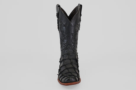 The Conor - Matte Black - Narrow Square Toe cowboy boot features textured, patterned fish leather and a brown sole, displayed upright and facing forward on a plain light gray background.