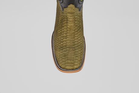 A top view of the Tanner - Green Jungle - Square Toe boot shows its olive green python leather, square toe, decorative stitching around the sole, and light brown outsole, embodying classic western style against a plain light background.