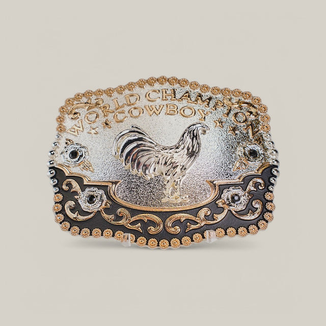 The Square Champion Rooster Buckle features a gold rooster at its center, surrounded by ornate western designs. World Champion Cowboy is engraved at the top, with intricate gold and alpaca silver detailing throughout.