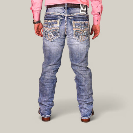 A person stands against a plain background wearing Western Blue Straight Fit Embroidered Jeans WJ-2349, a pink long-sleeve shirt, and brown shoes.