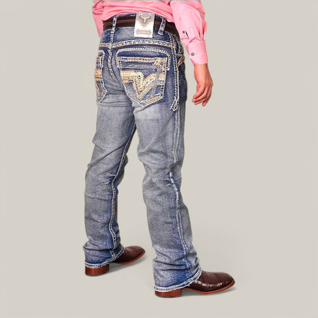A person in a pink shirt models Western Blue Straight Fit Embroidered Jeans (WJ-2345) with detailed back pocket embroidery, paired with brown cowboy boots. They stand against a gray backdrop, highlighting the jeans flattering fit and style.