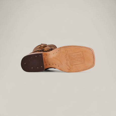 The Big Bass Pirarucu Print Rustic Honey - Square Toe boot features a brown design with a square toe, light tan leather sole with stitched details and subtle logo, plus a dark brown heel with visible nails for a classic Rustic Honey style.