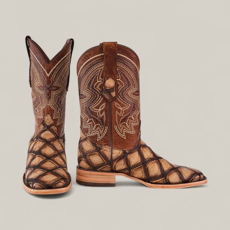 The Big Bass Pirarucu Print Rustic Camel - Square Toe boots feature intricate shaft stitching, a textured scale-like pattern on the foot, a tan sole, and are shown against a plain light background.