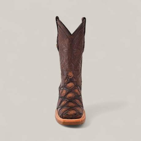 The Big Bass Pirarucu Print Rustic Brown - Rodeo Toe cowboy boot features intricate stitching and textured shaft and toe, shown from the front against a plain light gray background.