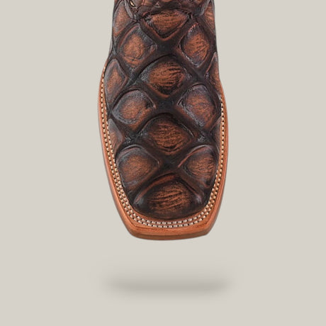 Close-up of the Rodeo Toe on the Big Bass Pirarucu Print Rustic Brown boot, featuring detailed stitching and a textured finish, displayed against a light beige background.