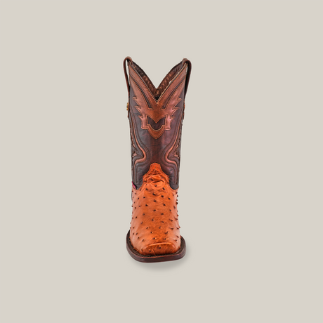 A single Exotic Ostrich - Brandy cowboy boot stands upright on a neutral background, displaying its expertly crafted ostrich leather with a textured finish, intricate stitching, and pointed rodeo toe, embodying exceptional craftsmanship.
